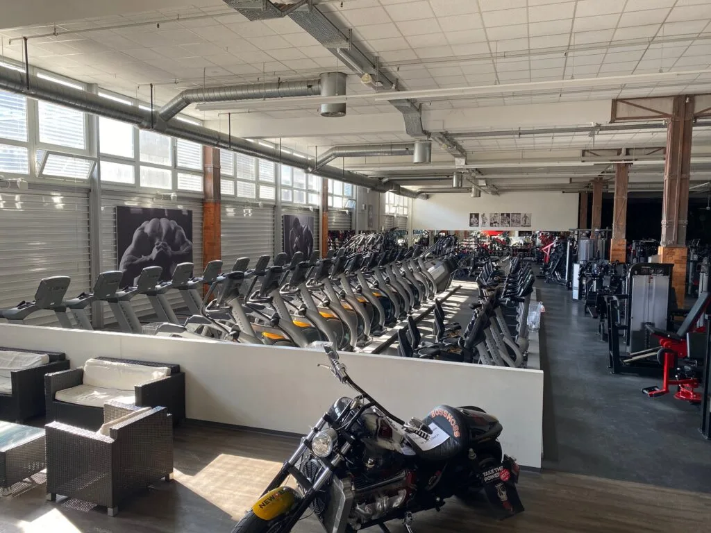 Rows of cardio machines fill the spacious David Gym floor with a motorcycle display.