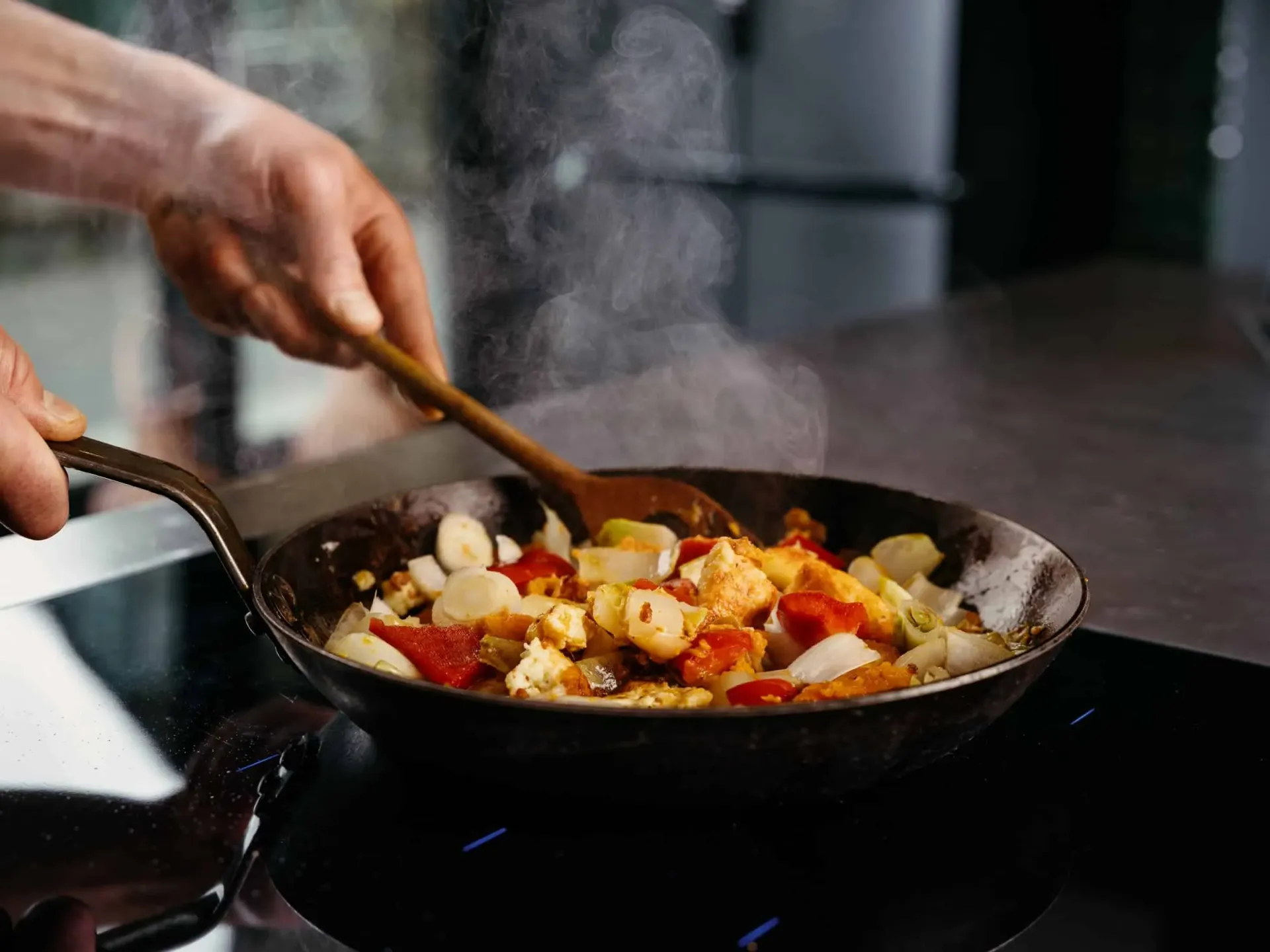 Three friends cooking together in a modern kitchen, embodying the communal, joyful approach to food that Astor Schneider promotes.