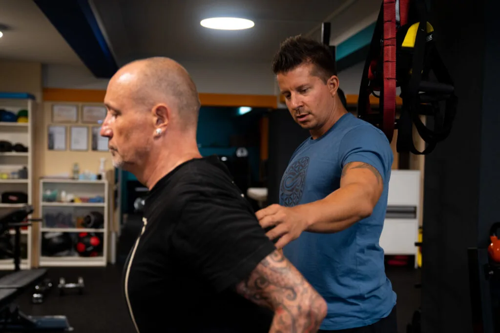 Man performing strength training with focus, demonstrating the integrated physical training approach at the studio.