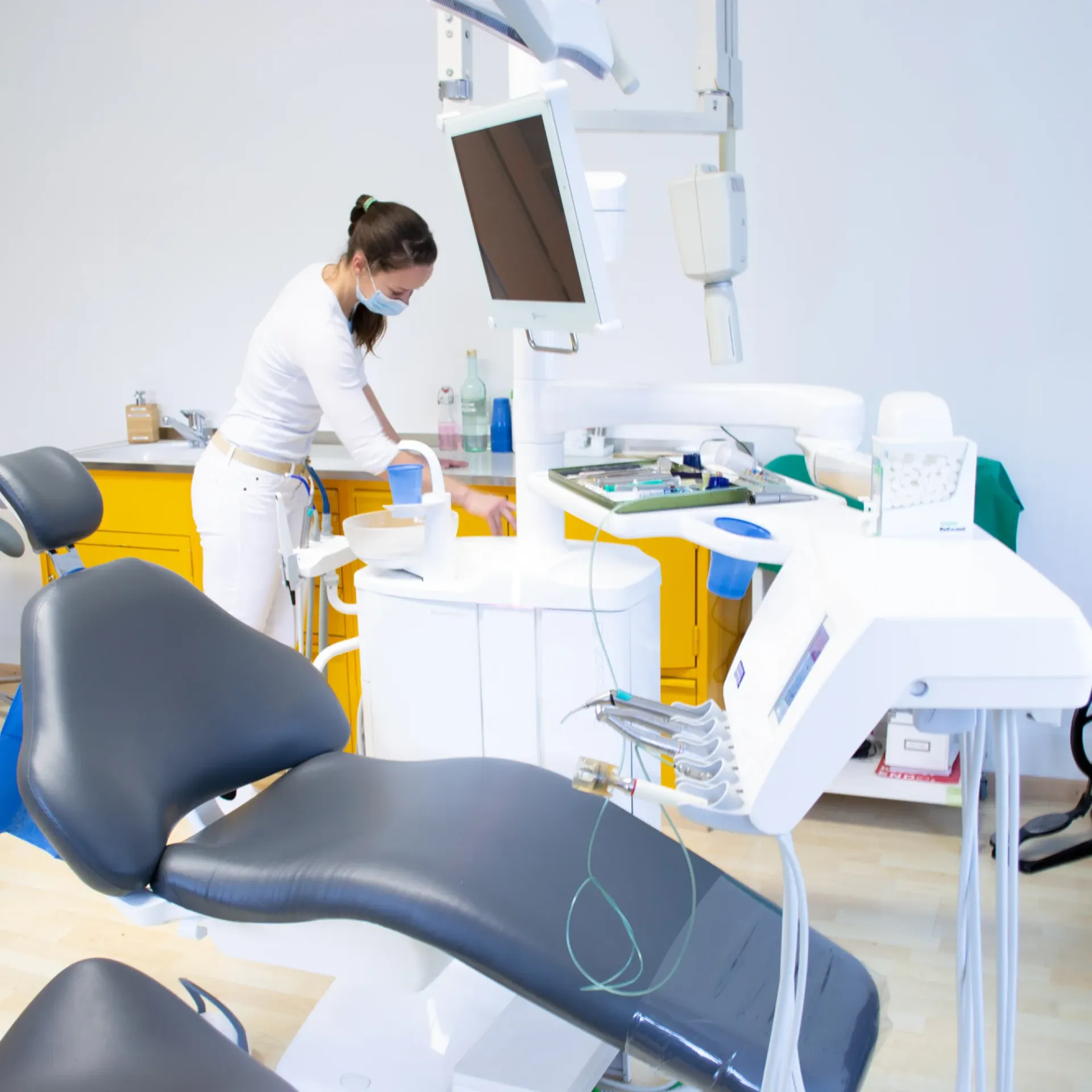 Bright, modern dental treatment room with a nurse in motion — conveys professionalism and the dynamic, caring atmosphere of the Zurich practice.