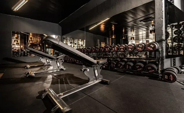 Fitness athlete with Gladiator Gym branding poses confidently, embodying the studio's philosophy of strength and self-discovery — ideal human-face hero image.