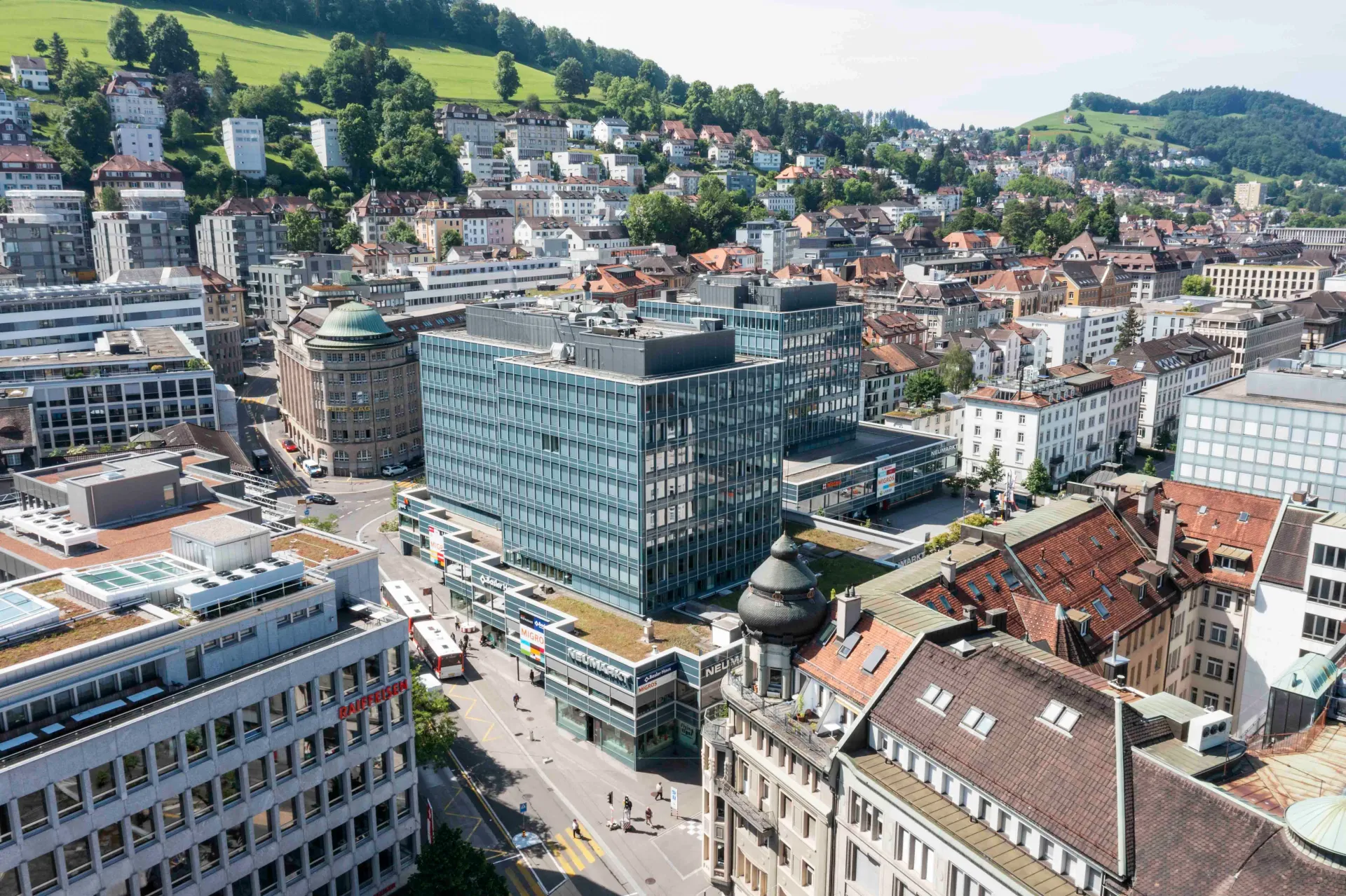 Aerial cityscape showing the modern glass-facade building where the dental practice HeilPraxis ZahnMedizin is located.