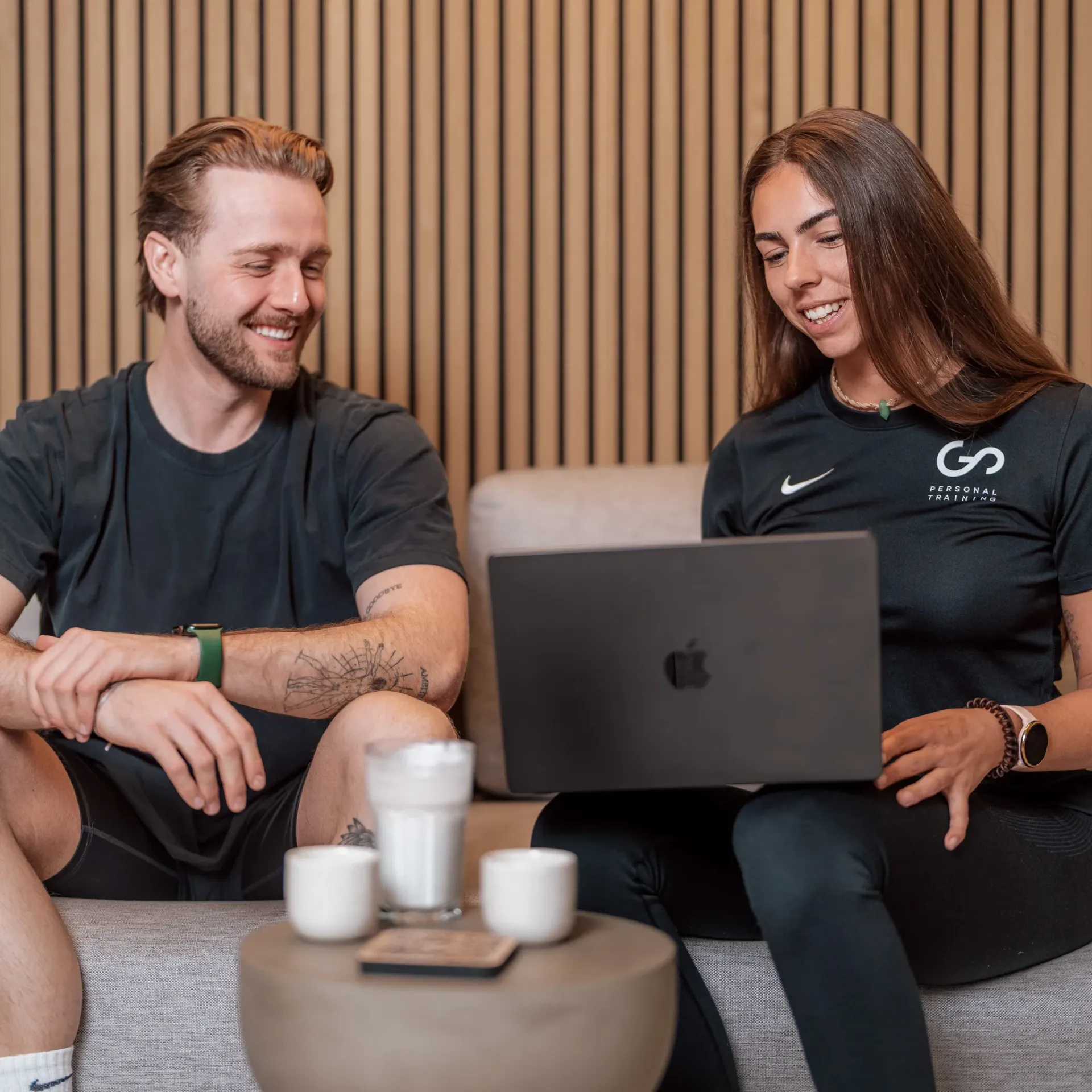 Trainer guiding a female client through an exercise, demonstrating the personalized one-on-one coaching philosophy of GO Personal Training.
