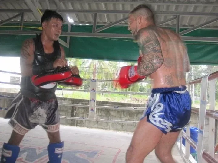 Oliver exchanges punches on the pads with a partner during an intense outdoor training session.