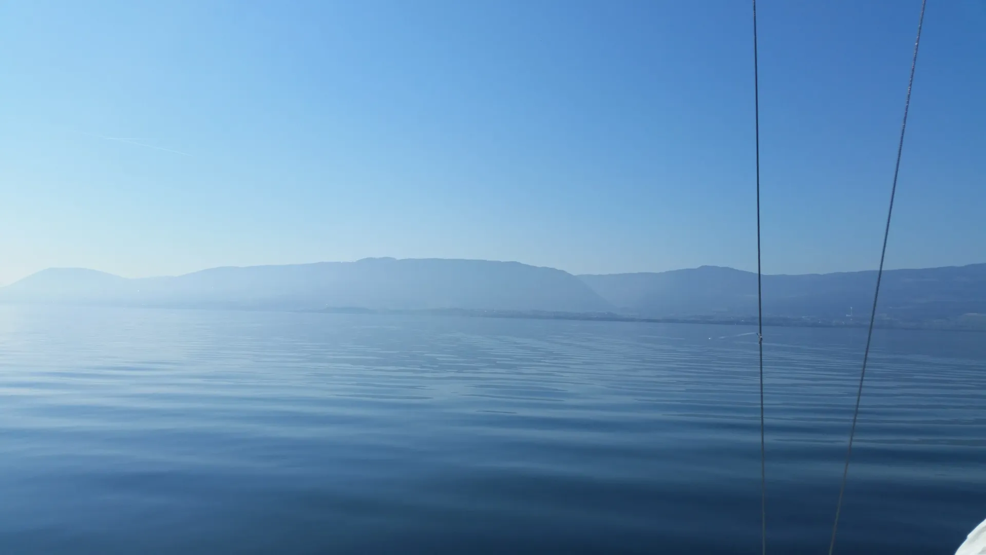 A serene, misty lake with gentle ripples and soft blue hues, evoking calm and introspection.