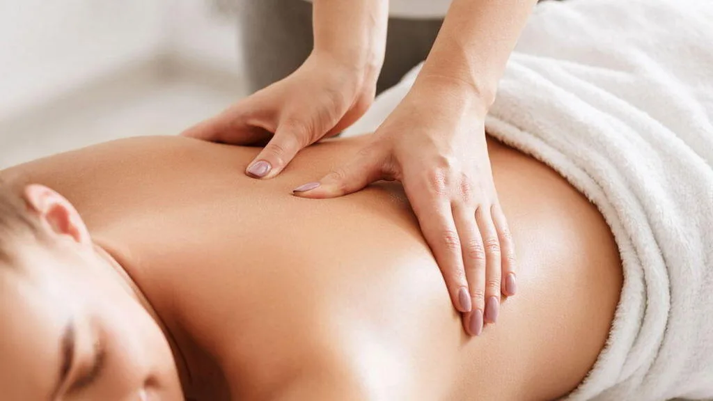 A woman receiving a relaxing head massage on a treatment table, perfectly illustrating the hands-on therapeutic care offered at bewusstgsund.