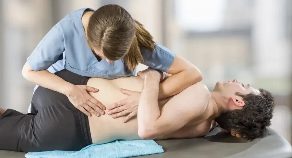 A physiotherapist performs hands-on abdominal treatment on a patient, powerfully illustrating the personal, skilled manual therapy offered at the practice.