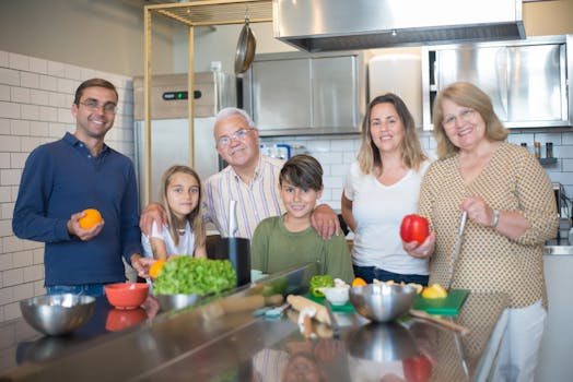 Eine Familie mit Kindern, Eltern und Grosseltern kocht gemeinsam in einer gemütlichen Küche und bereitet traditionelle Schweizer Gerichte zu.