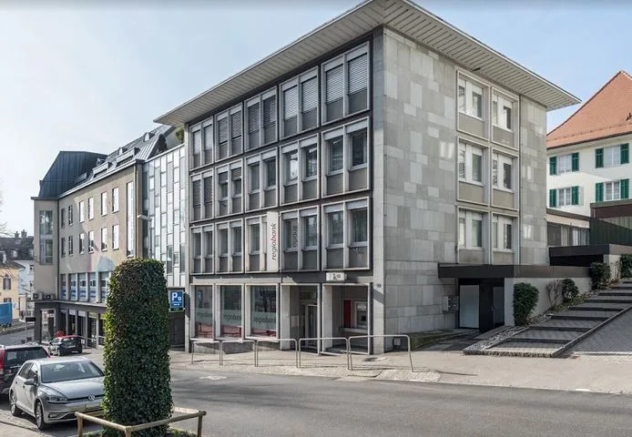 A modern multi-storey building housing the Naturmedizin Eggimann practice in an urban street setting.
