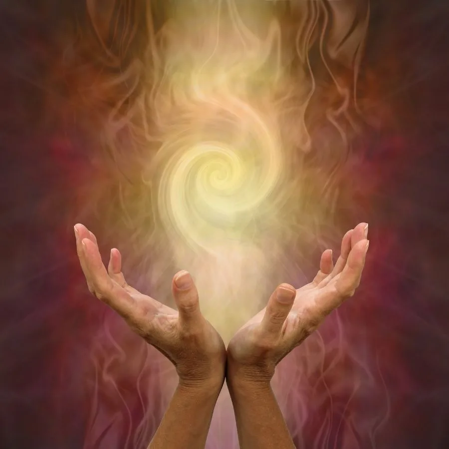 Two glowing hands hold a luminous swirling energy spiral symbolizing healing.